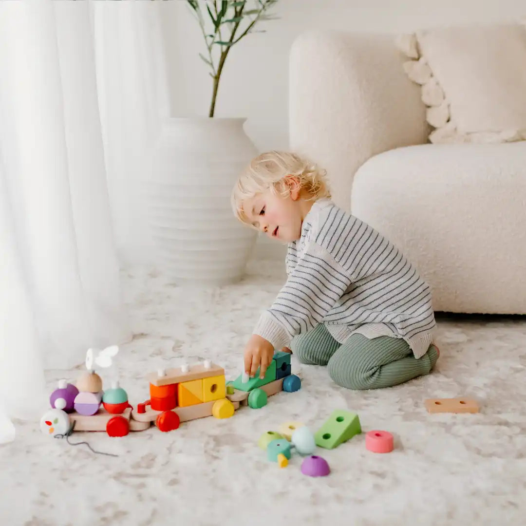 Child playing with wooden toy train.