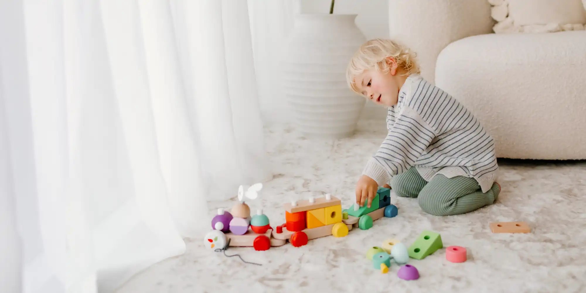 Child playing with wooden train.