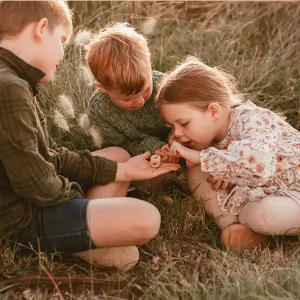 Three children examining dice.