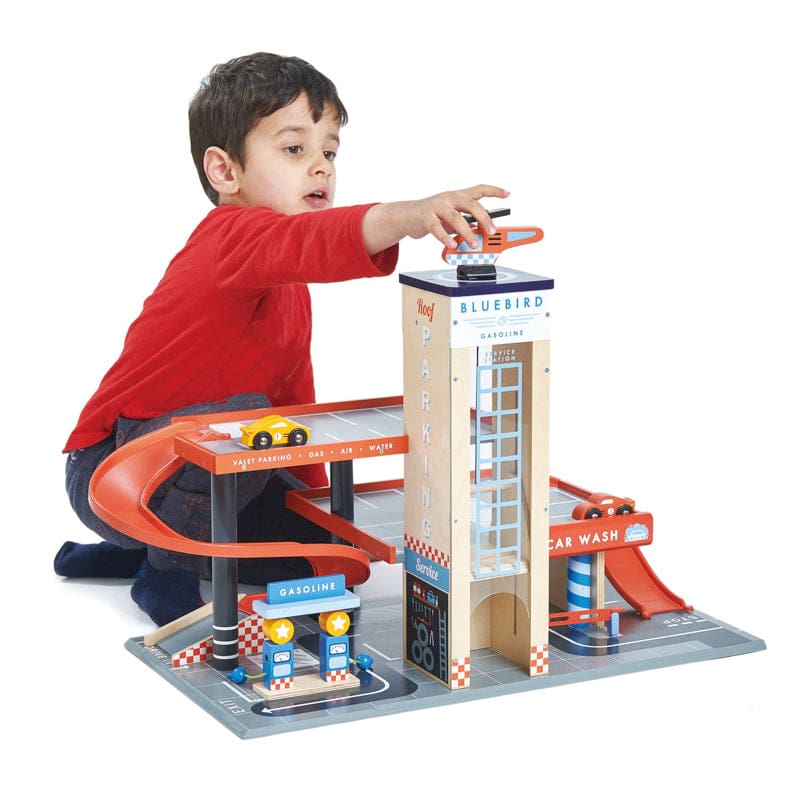 Child reaching for helicopter from Blue Bird Service Station toy by Tender Leaf