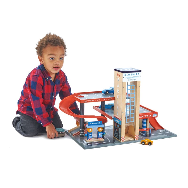 Child playing with Blue Bird Service Station. A wooden play set from Tender Leaf Toys