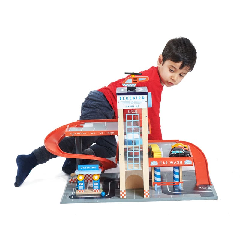 Child playing with wooden Blue Bird Service Station toy set