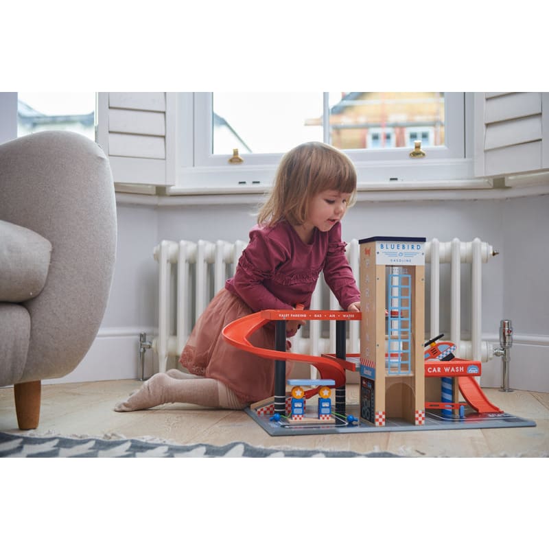 Girl playing with wooden Blue Bird Service Station by Tender Leaf Toys