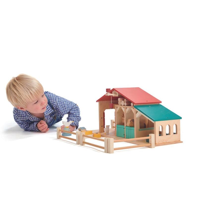 Child playing with Tender Leaf wooden farm set
